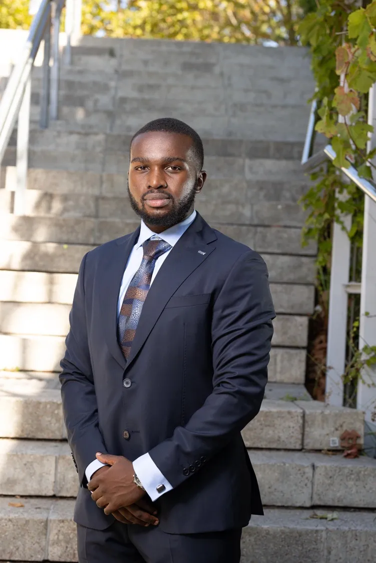 A Linea Consulting adviser in a navy suit, standing on a flight of stone steps outside an office building.
